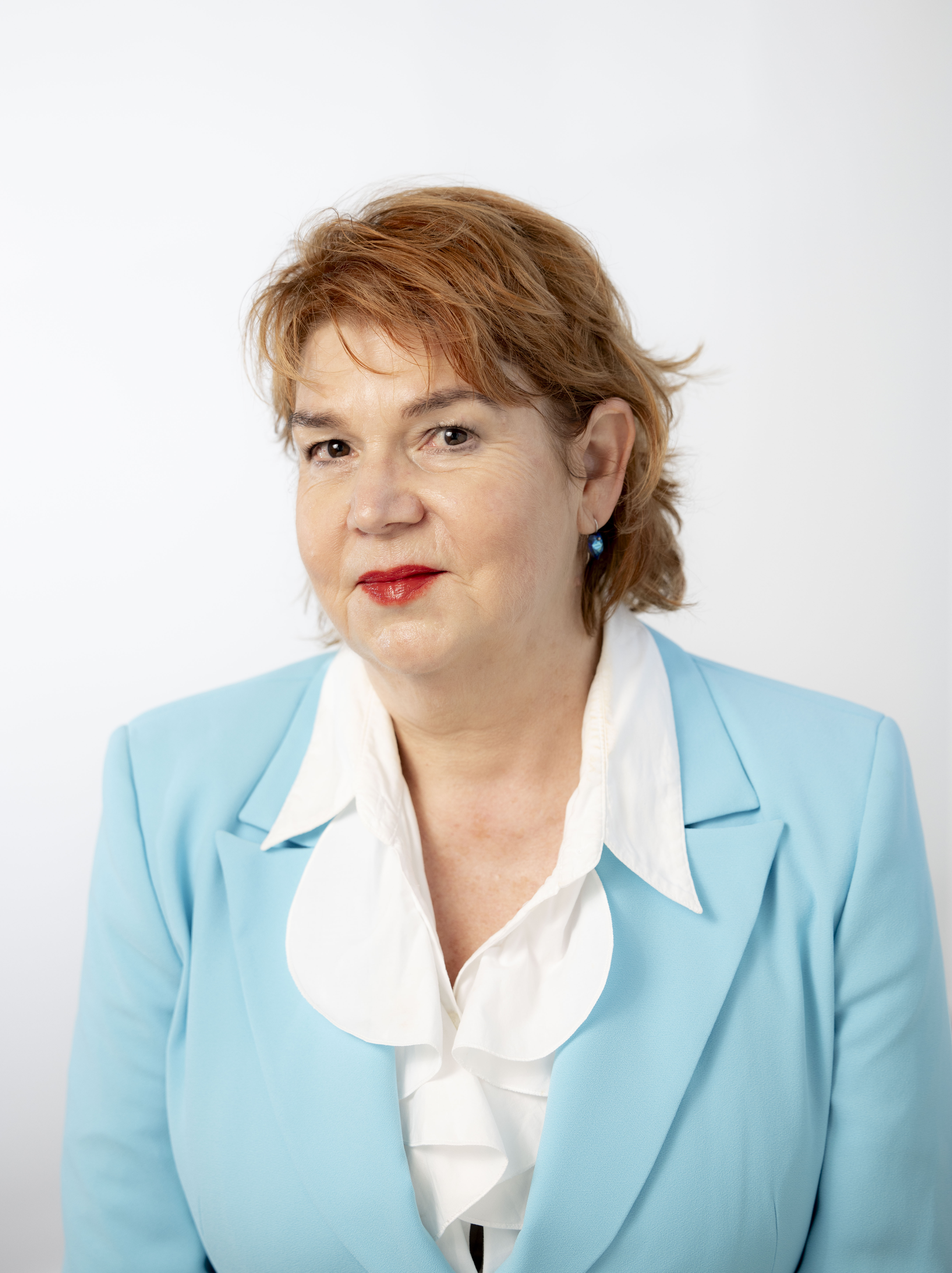 Professional photo of woman wearing red lipstick in a white button up shirt and blue blazer