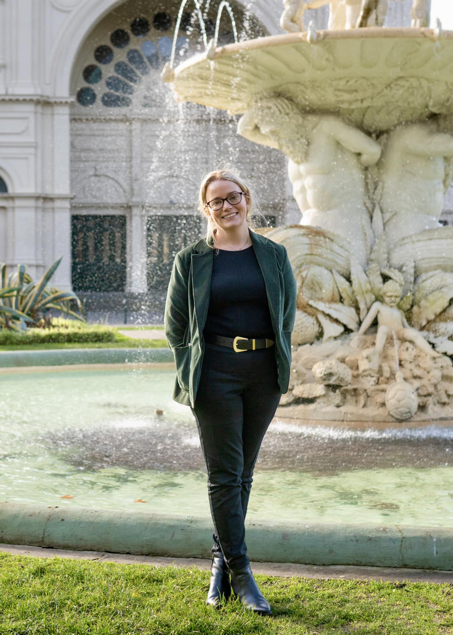 Woman standing in front of a large water fountain.