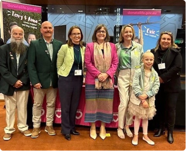 Six adults and a young child pose for a group photo