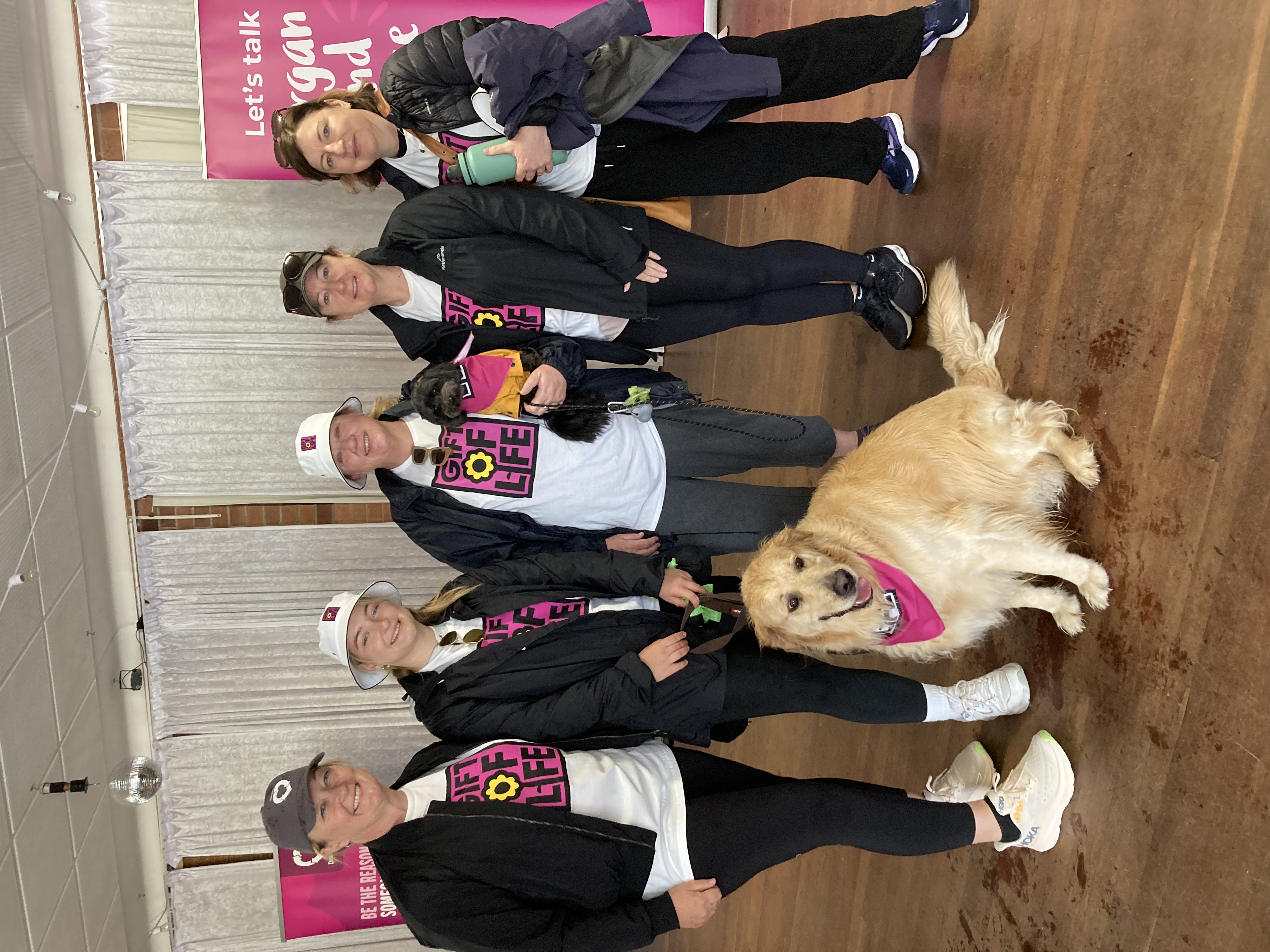 A group of people and a golden retriever, dressed in Gift of Life shirts and hats.