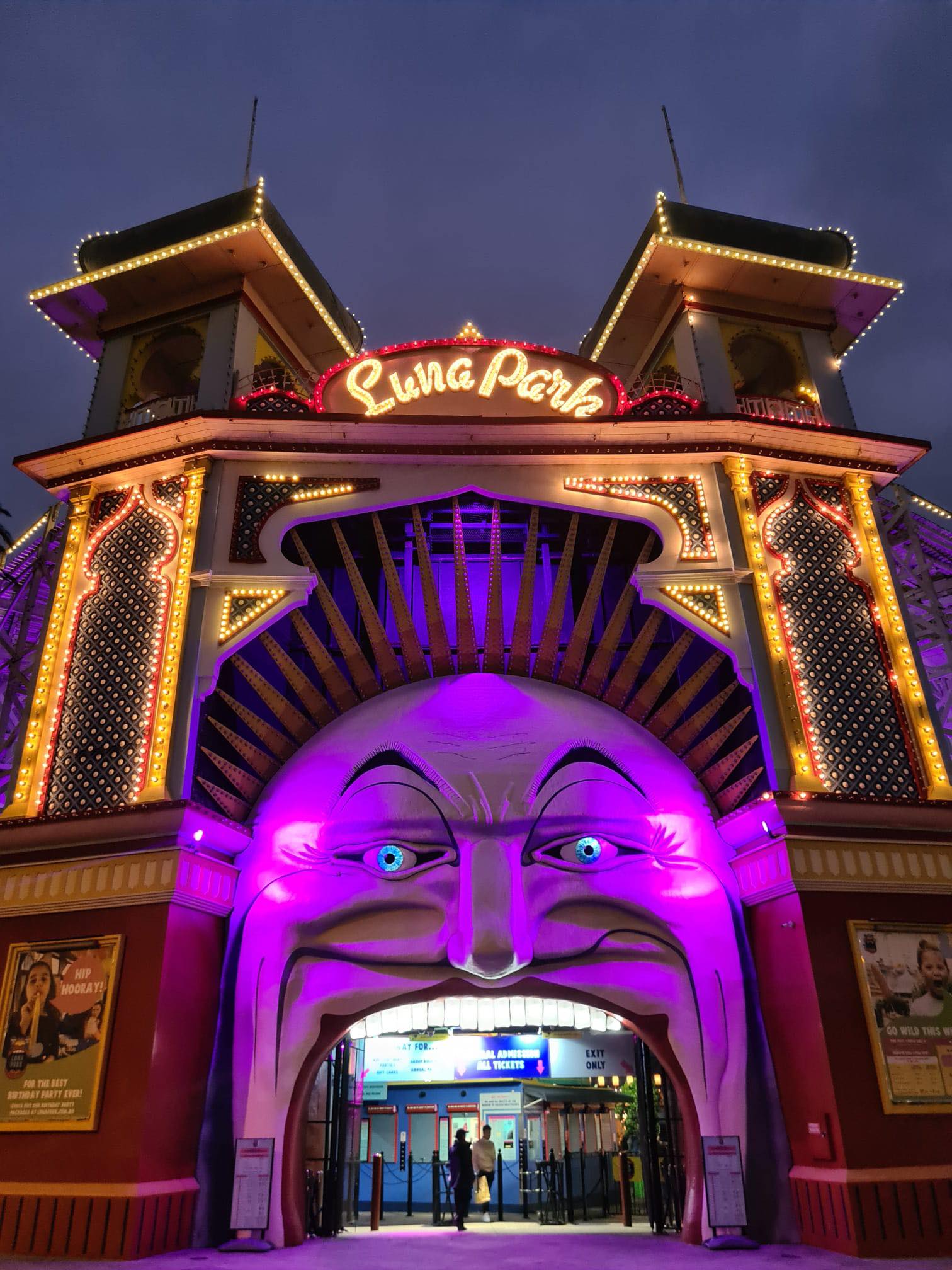 : The entry of Luna Park, Melbourne is pictured at night lit up in magenta. 