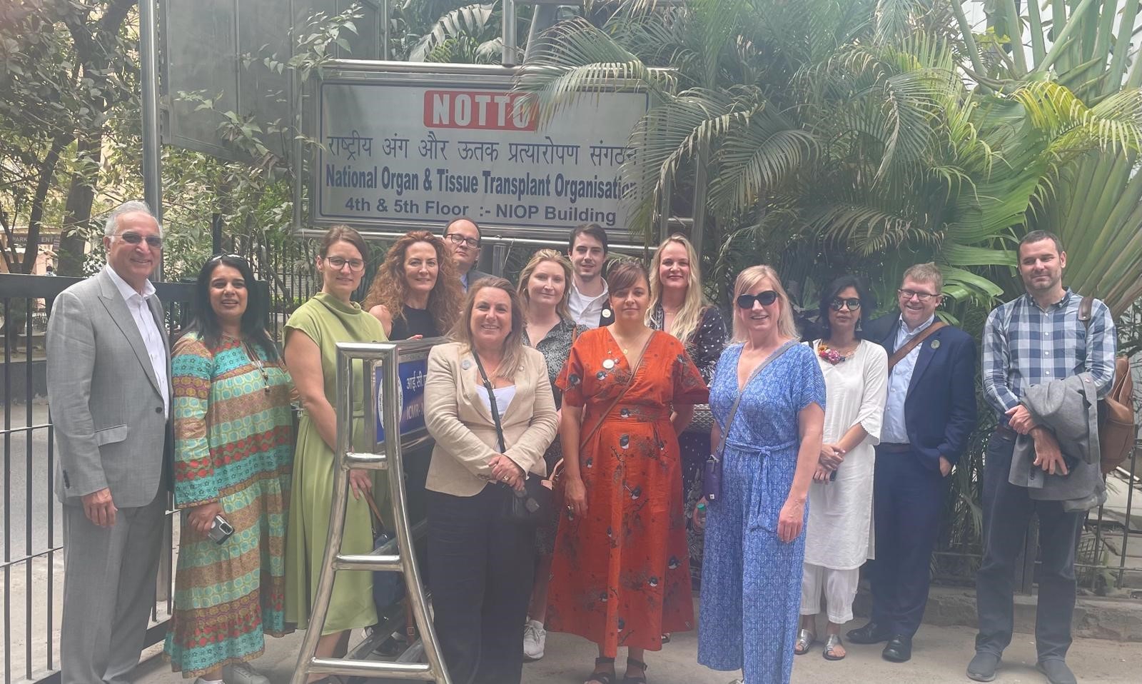 A group photo of delegates in front of a sign for India’s National Tissue and Transplant Organisation.