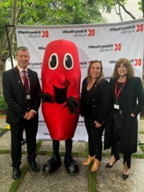 A photo of CEO Lucinda Barry with Chris Forbes, Prof Carol Pollock and a kidney mascot.  