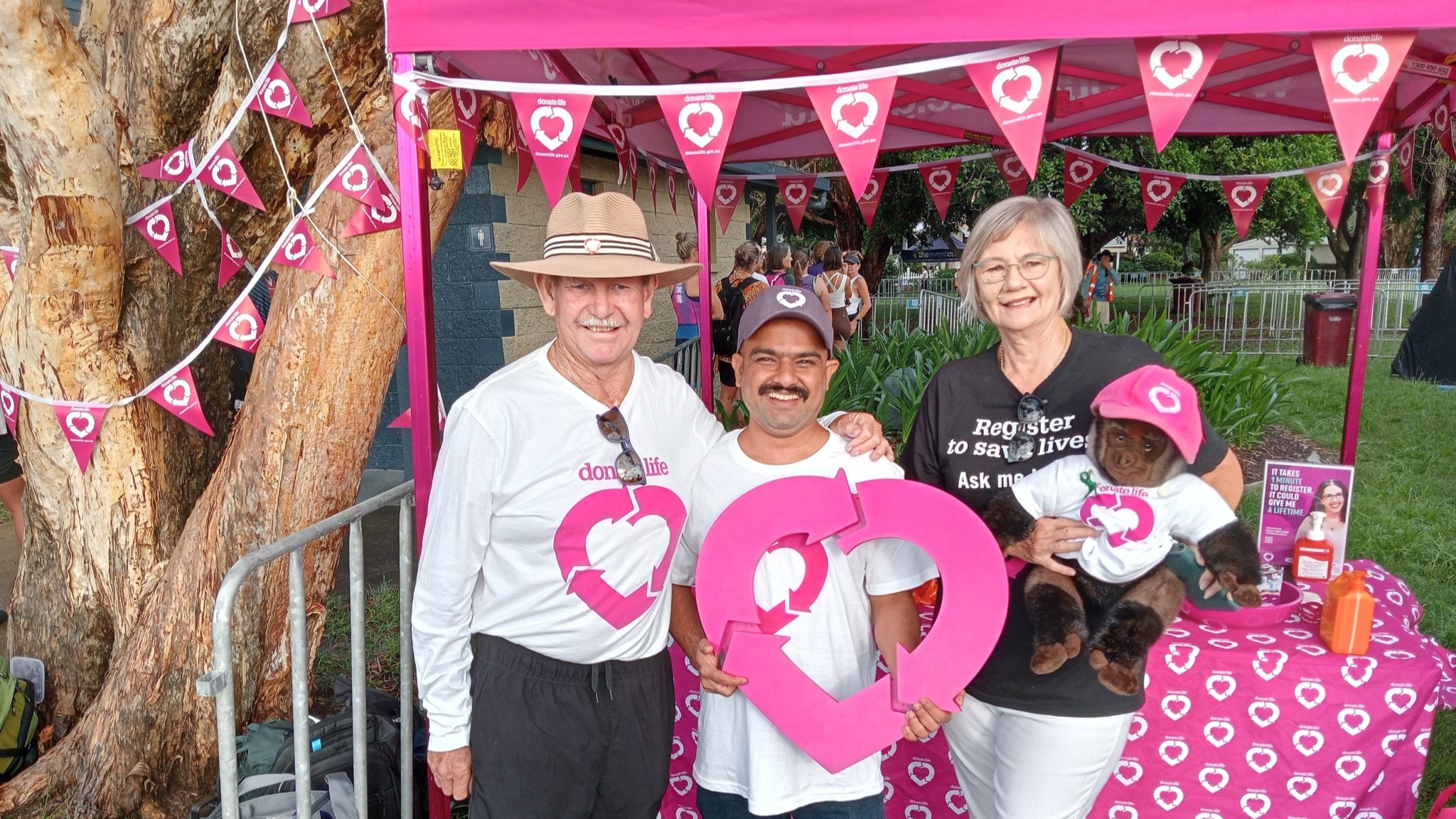 Three people pose at a DonateLife stall