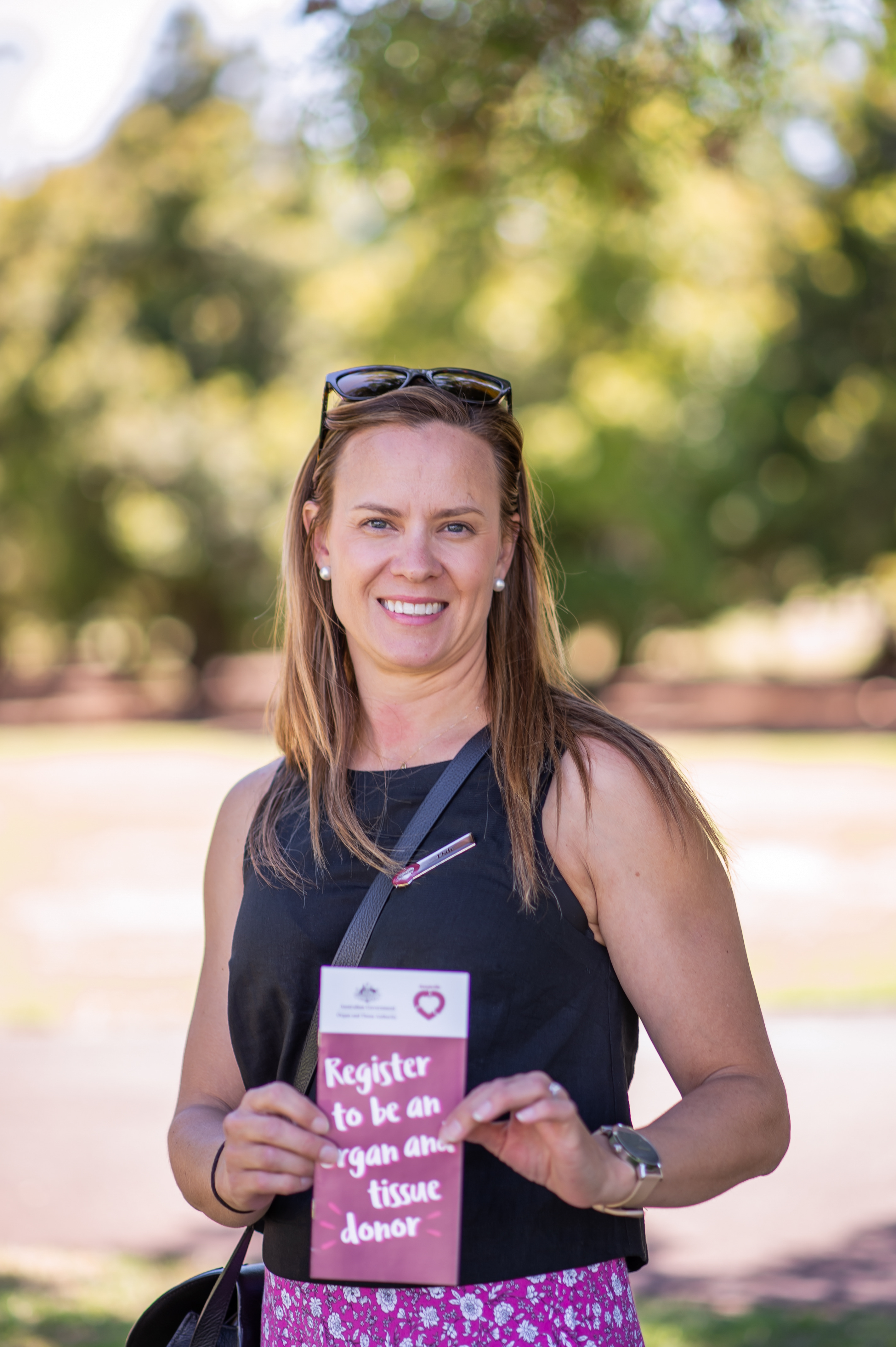 A photo of a woman holding up a DonateLife brochure. 