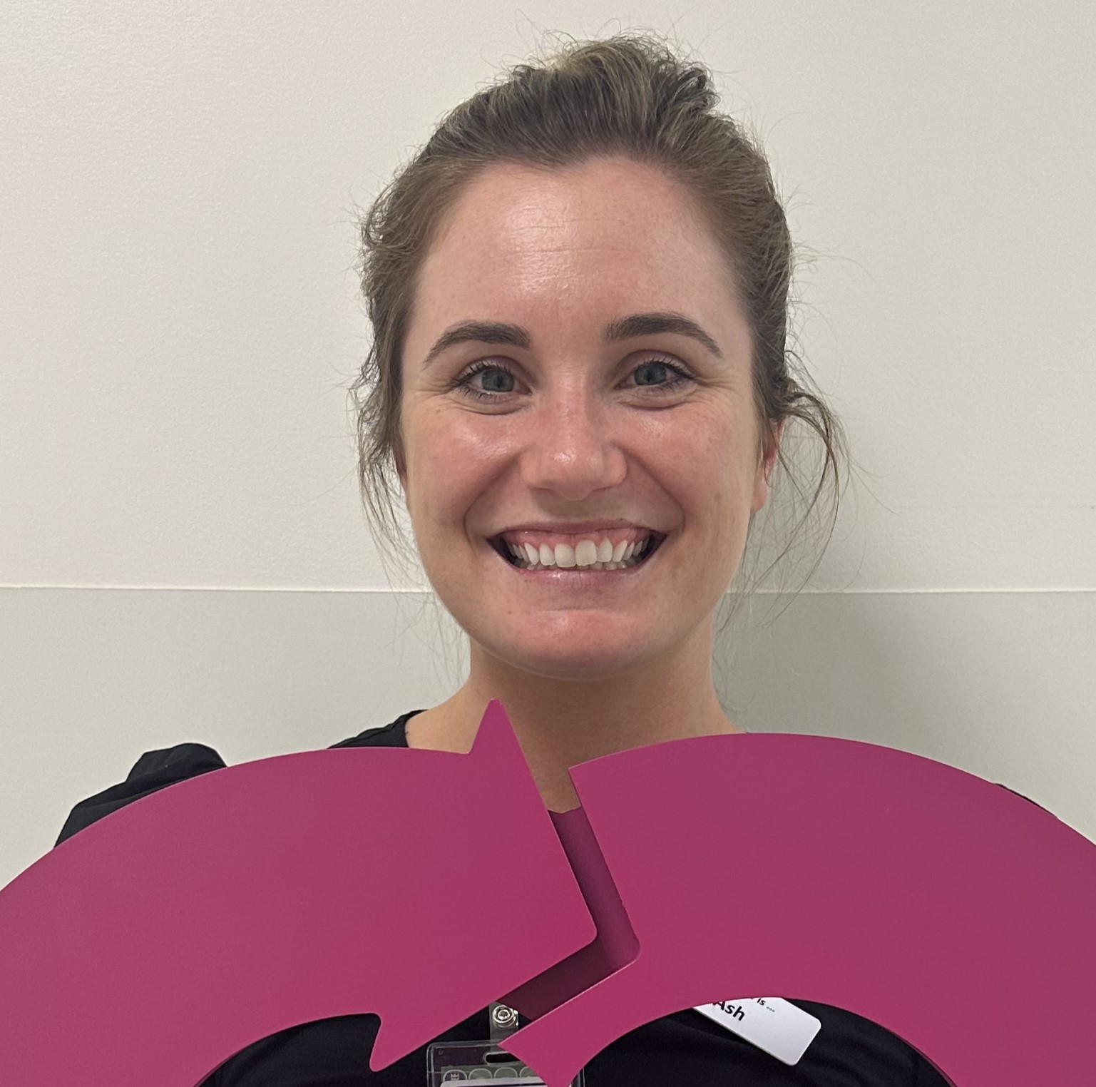 A woman holding the DonateLife heart logo and smiling at the camera. 