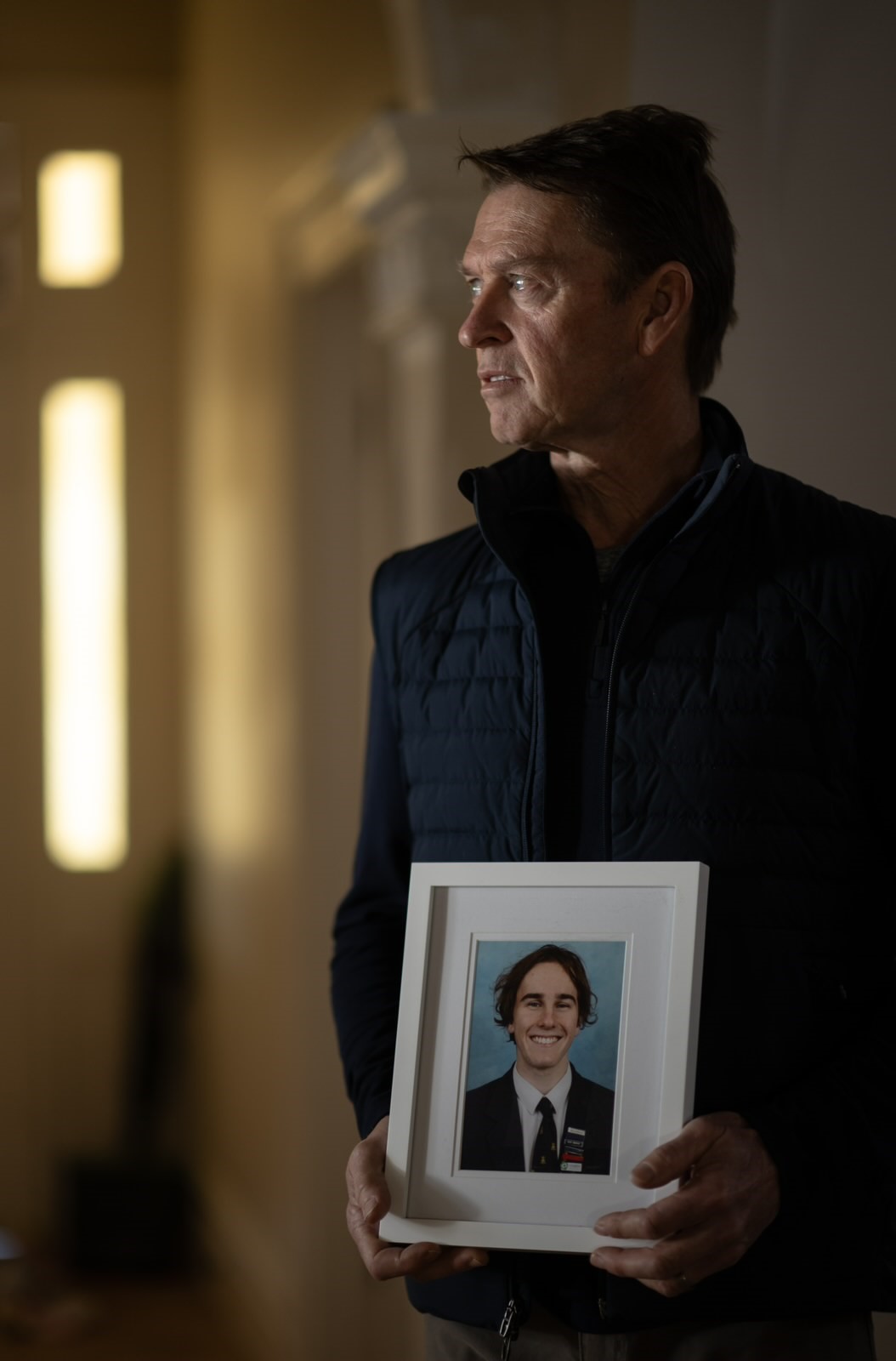 Brad van Dijk, speaker at the NSW Service of Remembrance, holding a photo of his son, organ donor Tom van Dijk.