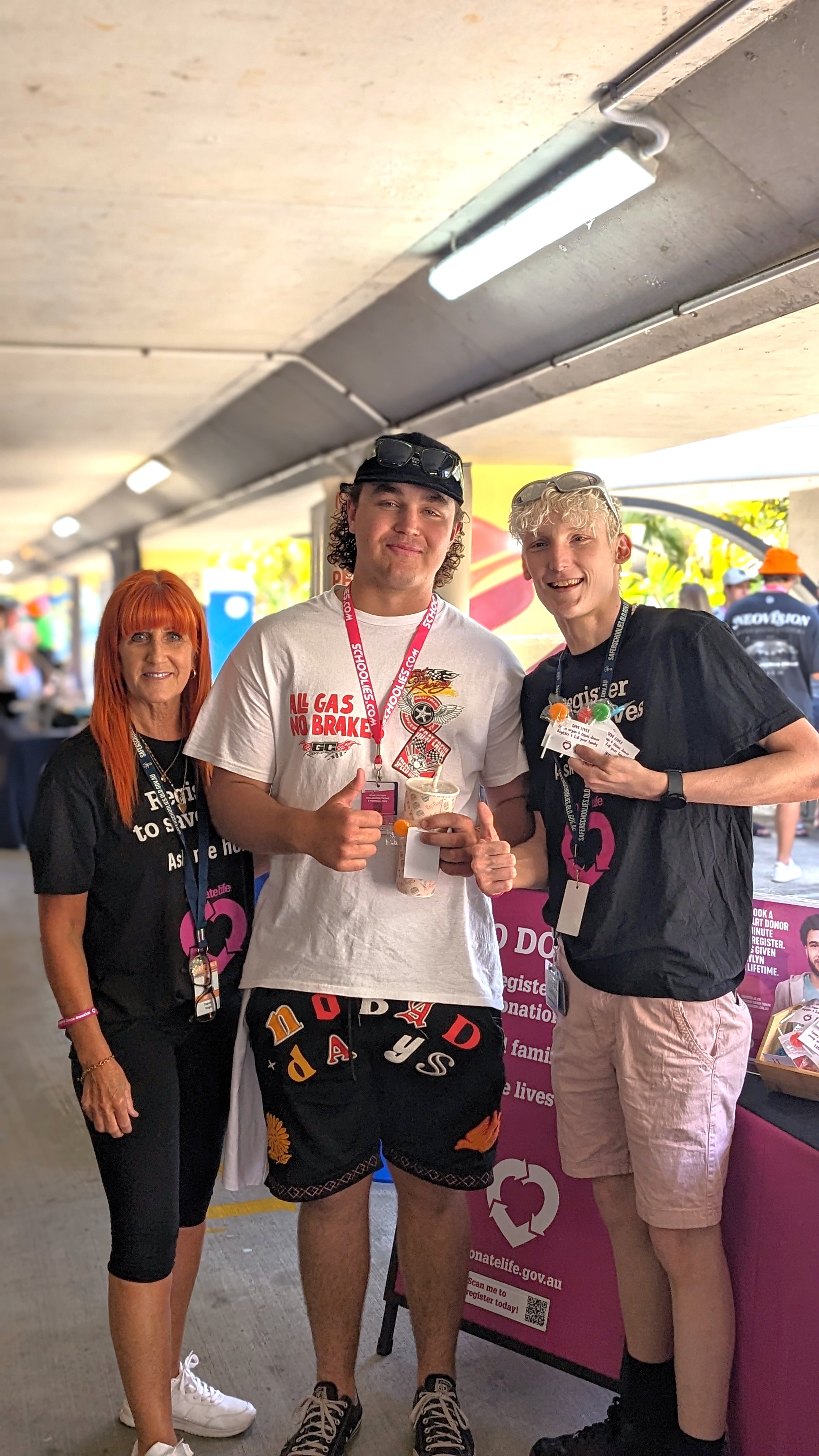 DonateLife Queensland Community Champions Tracey and Jordan with a Schoolies attendee in front of the DonateLife stand at Schoolies Registration Day. 